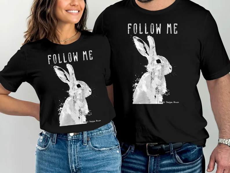 Two people wearing black Follow Me rabbit T-shirts